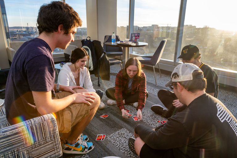 Four students eating snacks and playing board games