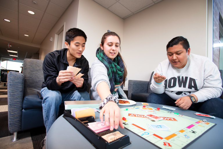 Students playing a board game and eating popcorn