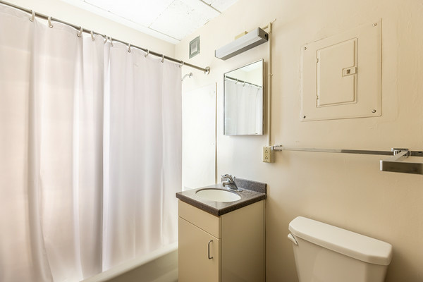 bathroom in a Parklawn studio, shown with shower and bathtub, sink and mirror toilet