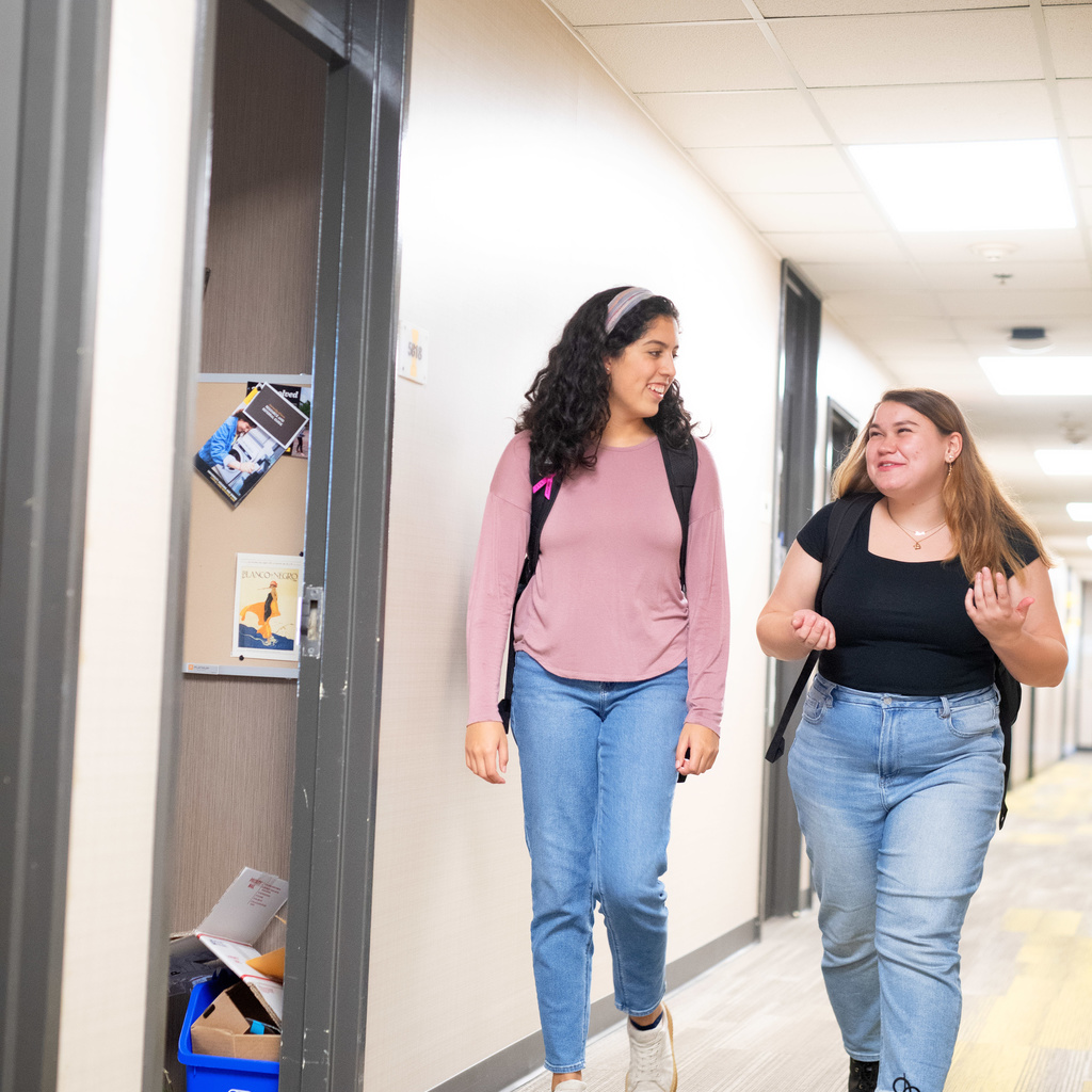 Two students walking down a hallway