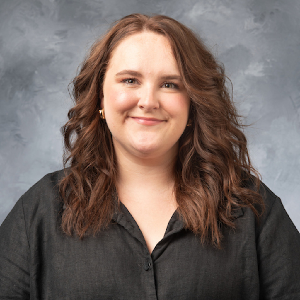 Dani Dunphy, hall coordinator. White woman with brown hair and black buttondown shirt