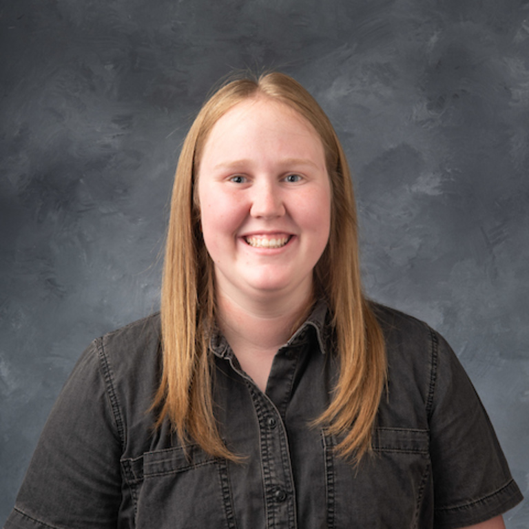 portrait of blond woman with dark gray short sleeve button down