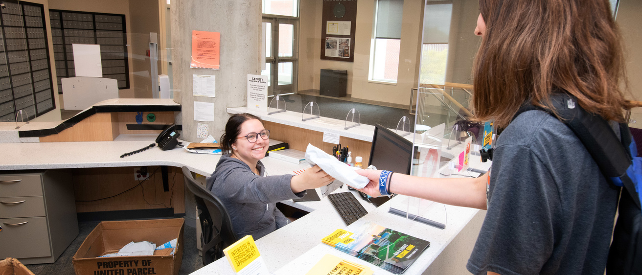 Student handing a package to another student