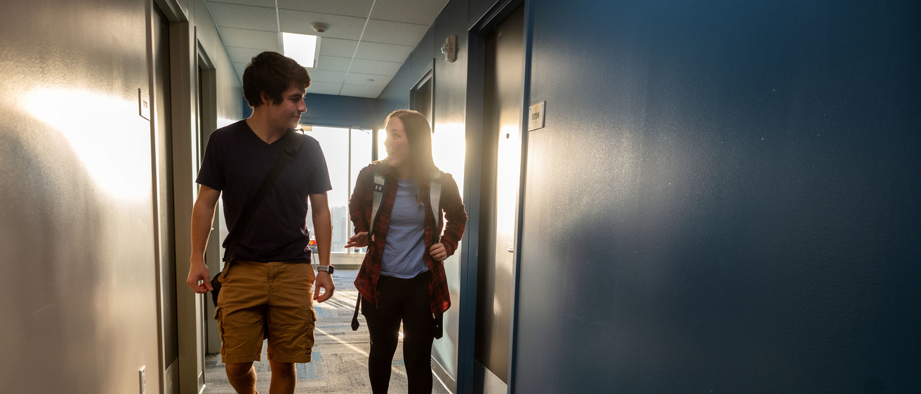 Two students walking down a hallway